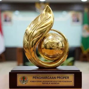 Trophy Penghargaan Proper berlapis emas dari Kementerian Lingkungan Hidup dan Kehutanan RI, menampilkan simbol daun dan bumi, dipamerkan di meja ruang rapat dengan deretan bendera Indonesia dan atribut lembaga di belakangnya—terkait implementasi standar lingkungan sesuai peraturan BPLH nomor 7 tahun 2025.