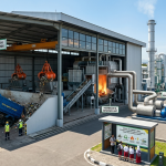 Waste to energy adalah proses pengolahan sampah menjadi energi listrik yang ditunjukkan pada fasilitas modern dengan truk pengangkut sampah, sistem pemilahan organik dan anorganik, insinerator pembakar limbah, serta turbin uap dan generator listrik yang menghasilkan energi bersih di area industri.